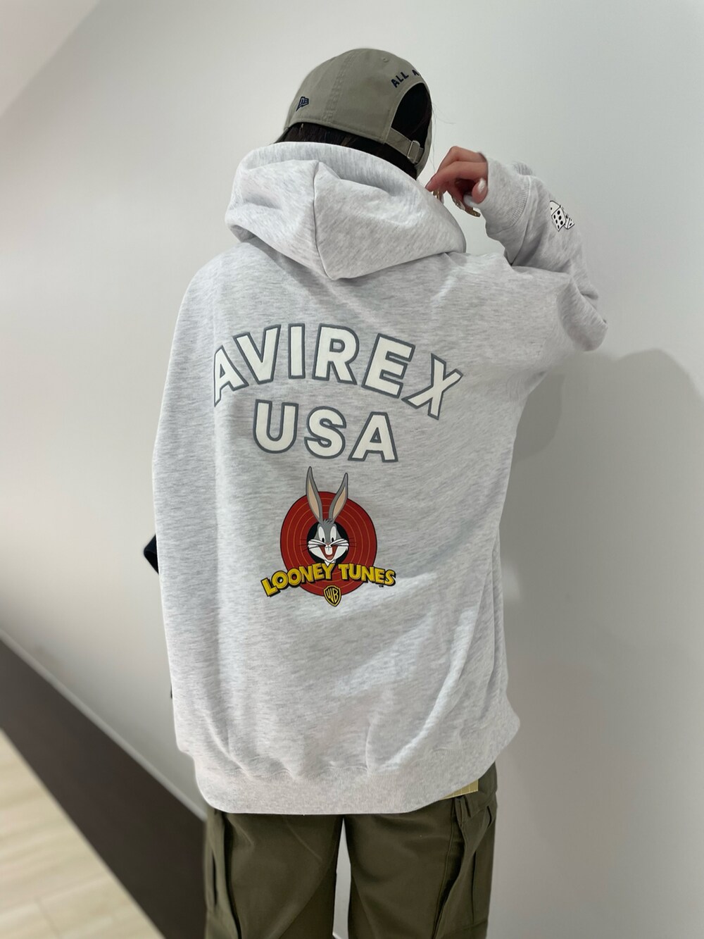 グリーン系のカーゴパンツ、グレー系のパーカー、ベージュ系の帽子を着用したレディースの冬コーディネートの2枚目の写真