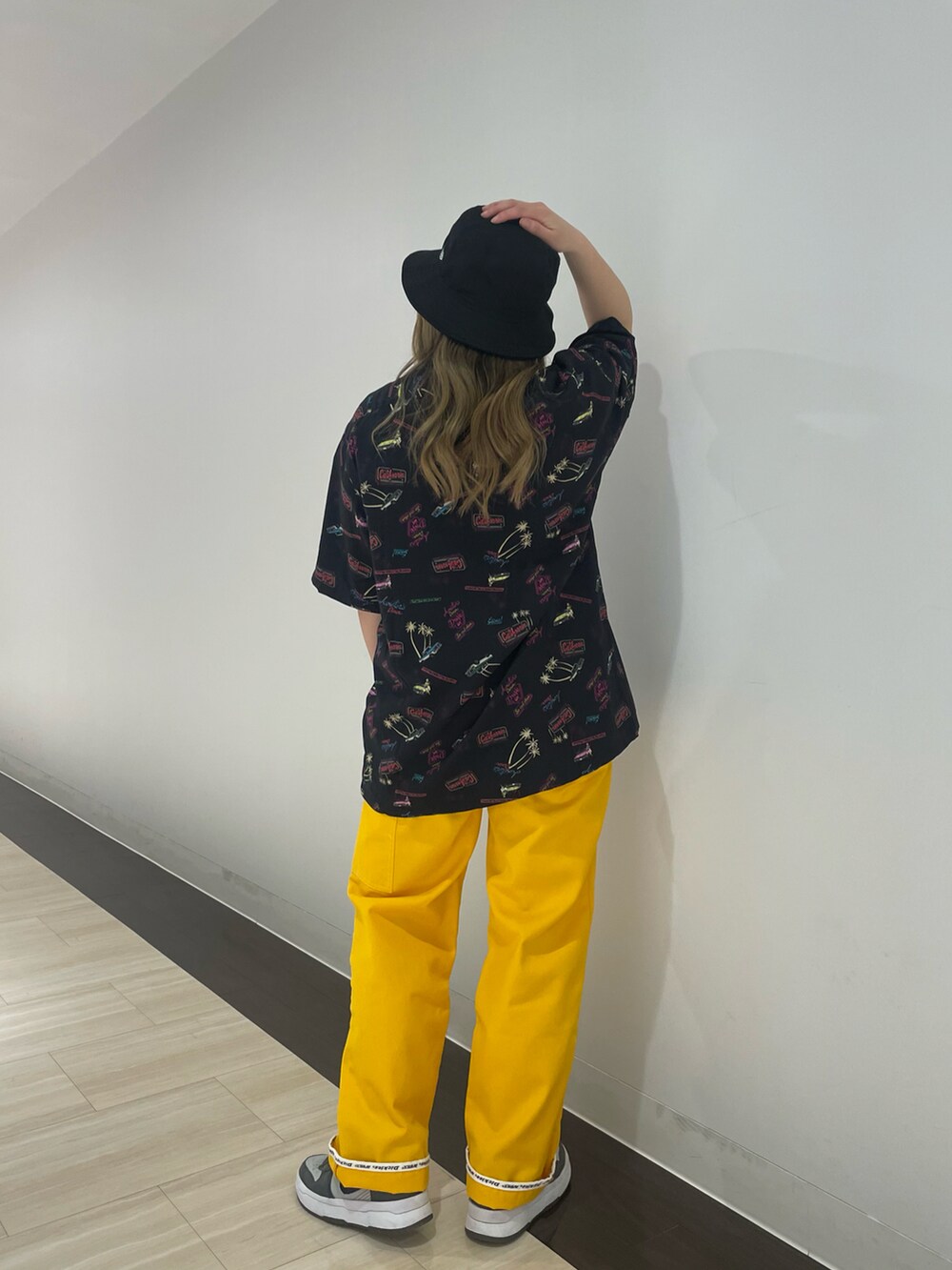 イエロー系のカーゴパンツ、ブラック系のシャツ/ブラウス、ブラック系のハットを着用したレディースの春コーディネートの3枚目の写真