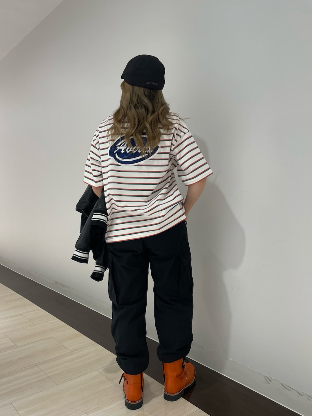 ブラック系のカーゴパンツ、ピンク系のTシャツ/カットソー、ブラック系のスタジャンを着用したレディースの春コーディネートの3枚目の写真