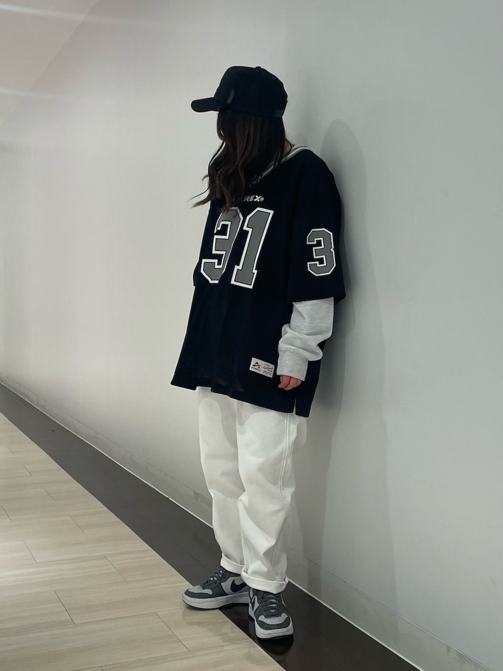 ホワイト系のデニムパンツ、グレー系のスウェット、ブラック系のキャップを着用したレディースの冬コーディネートの3枚目の写真