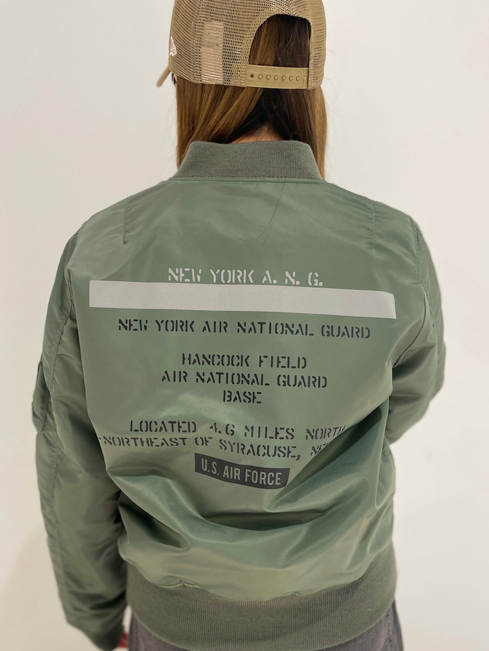 ブルー系のデニムパンツ、グリーン系のMA-1、ブラック系のTシャツ/カットソーを着用したレディースの夏コーディネートの4枚目の写真