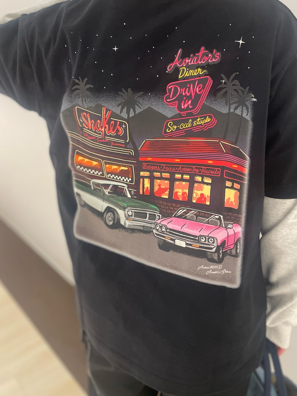 ブラック系のTシャツ/カットソー、ブラック系のカーゴパンツ、その他のトートバッグを着用したレディースの春コーディネートの4枚目の写真