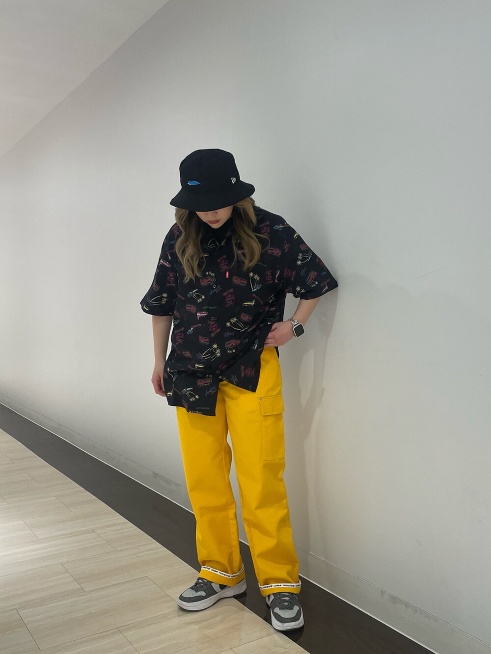 イエロー系のカーゴパンツ、ブラック系のシャツ/ブラウス、ブラック系のハットを着用したレディースの春コーディネートの2枚目の写真
