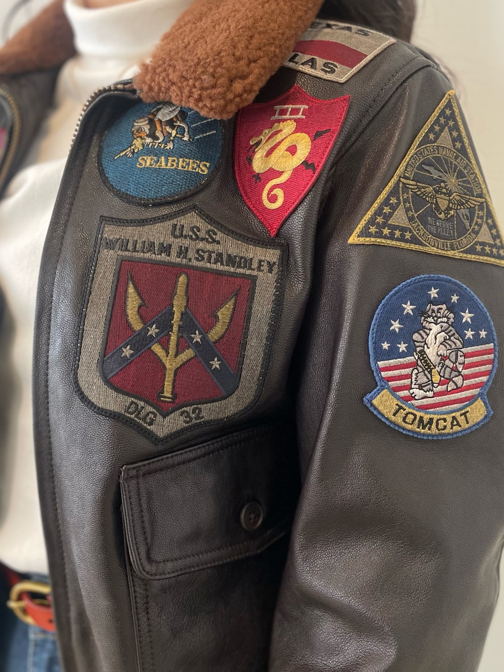 ブルー系のデニムパンツ、ブラウン系のミリタリージャケット、イエロー系のベルトを着用したレディースの春コーディネートの3枚目の写真