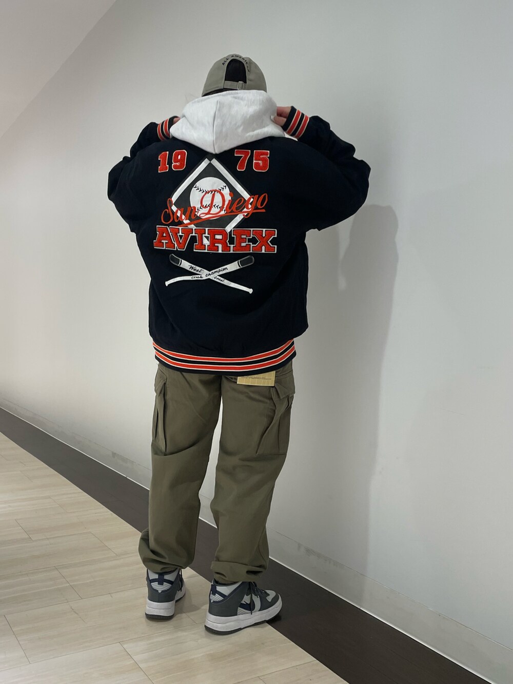 グレー系のパーカー、グリーン系のカーゴパンツ、ブラック系のスタジャンを着用したレディースの冬コーディネートの2枚目の写真