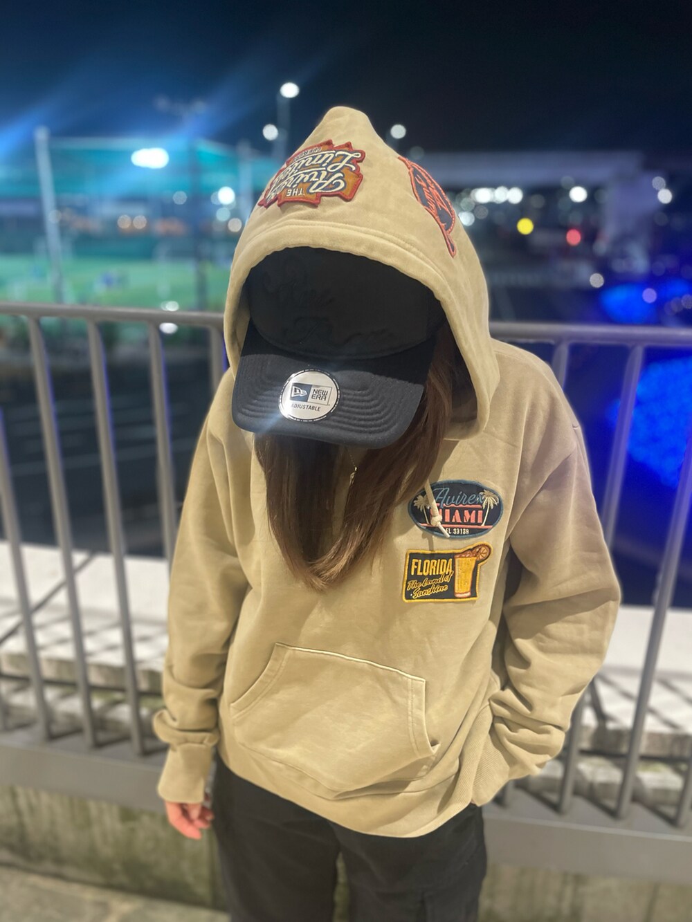 ブラック系のカーゴパンツ、ベージュ系のパーカー、ブラック系のキャップを着用したレディースの冬コーディネートの2枚目の写真