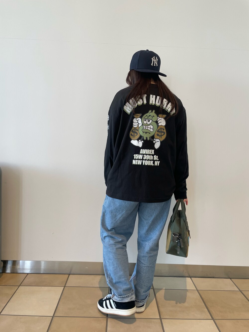 グリーン系のボストンバッグ、ブラック系のTシャツ/カットソーを着用したレディースの冬コーディネートの2枚目の写真