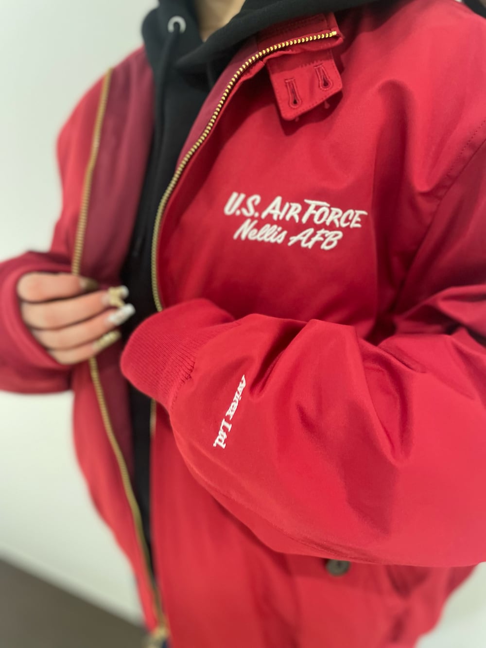その他のデニムパンツ、レッド系のミリタリージャケット、ブラック系のパーカーを着用したレディースの冬コーディネートの3枚目の写真