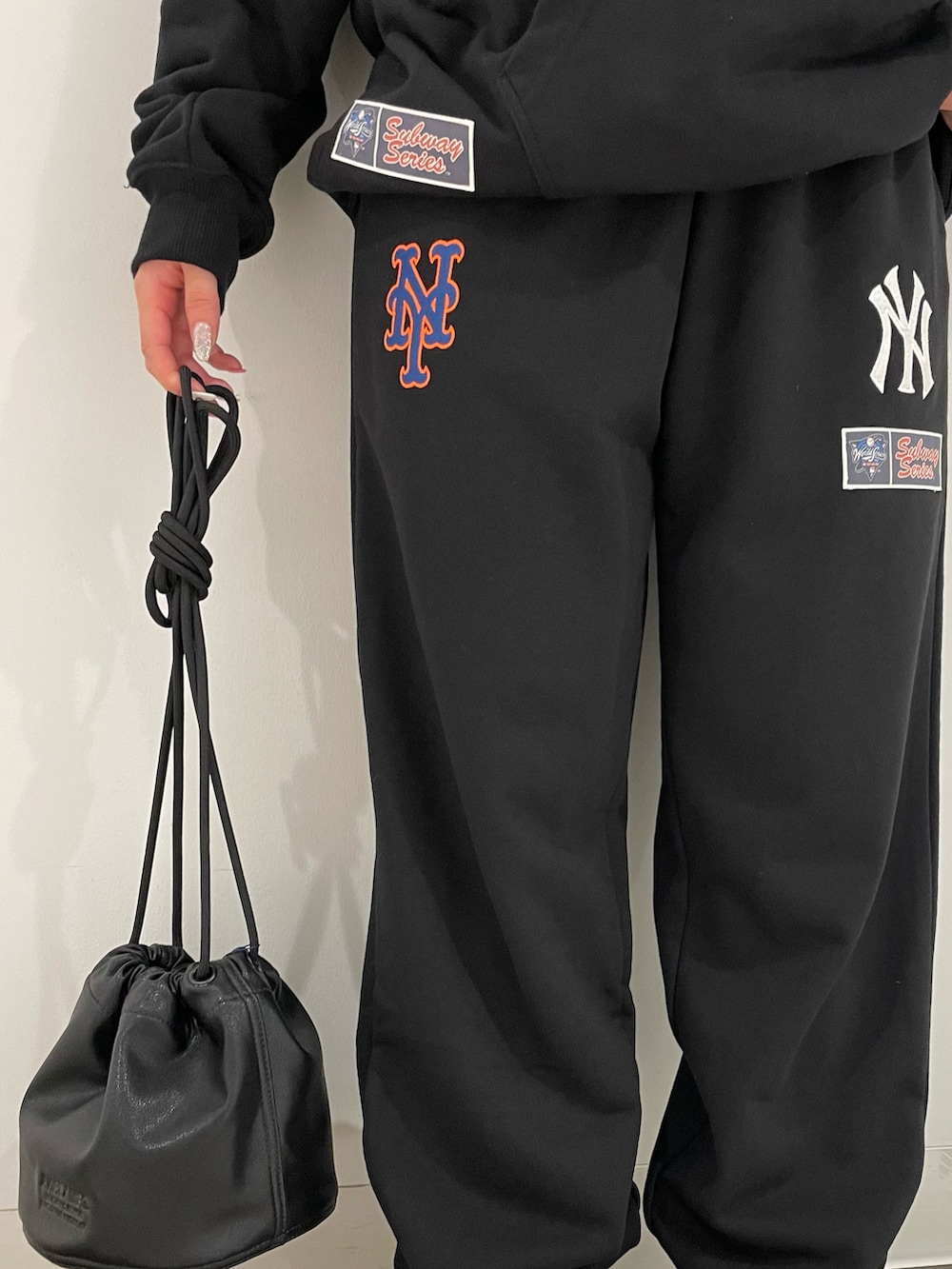 ブラック系のショルダーバッグ、ブラック系のパーカー、ブラック系のスウェットパンツを着用したレディースの夏コーディネートの3枚目の写真