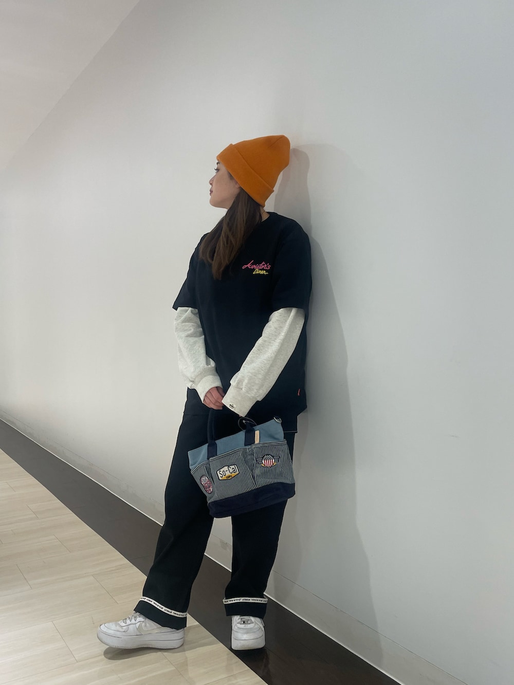 ブラック系のTシャツ/カットソー、ブラック系のカーゴパンツ、その他のトートバッグを着用したレディースの春コーディネートの2枚目の写真