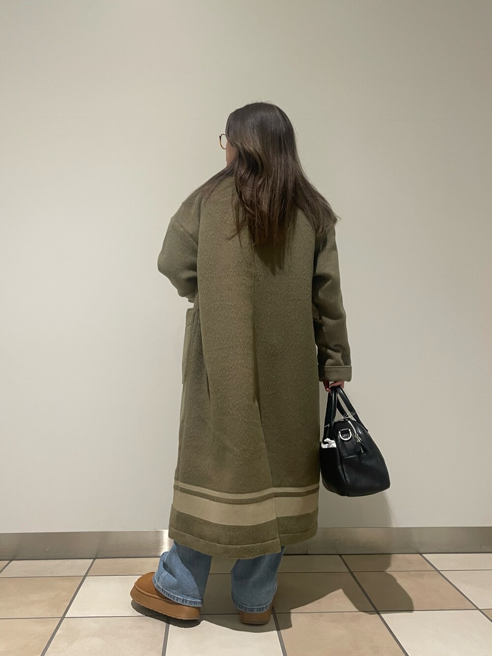 ブラック系のボストンバッグ、グリーン系のその他アウターを着用したレディースの秋コーディネートの3枚目の写真