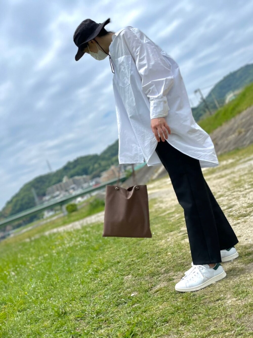 ブラック系のスラックス、ホワイト系のシャツ/ブラウス、ブラウン系のトートバッグを着用したレディースの春コーディネートの3枚目の写真