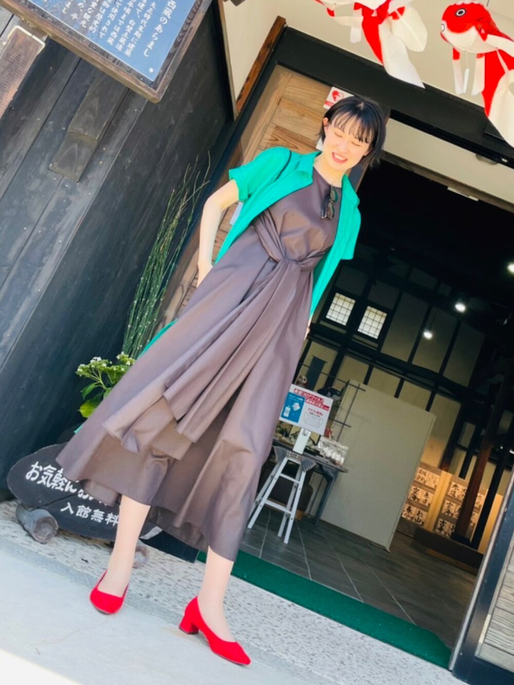 ブラウン系のワンピース、グリーン系のシャツワンピース、レッド系のパンプスを着用したレディースの夏コーディネートの2枚目の写真