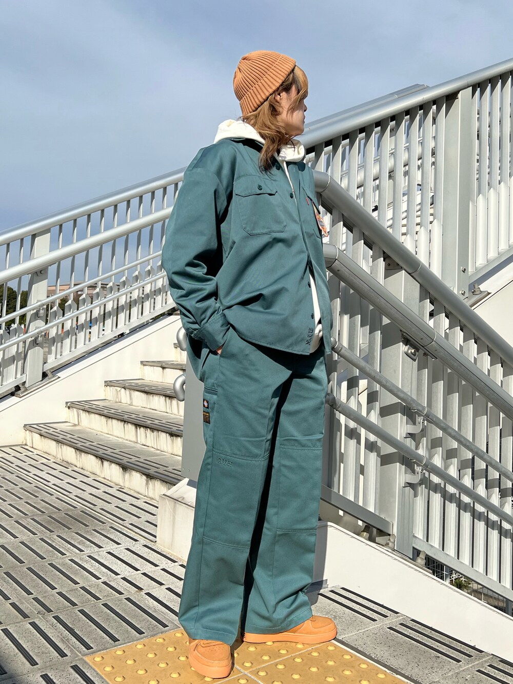 グリーン系のシャツ/ブラウス、グリーン系のチノパンツ、ゴールド系のスニーカーを着用したレディースの冬コーディネートの2枚目の写真