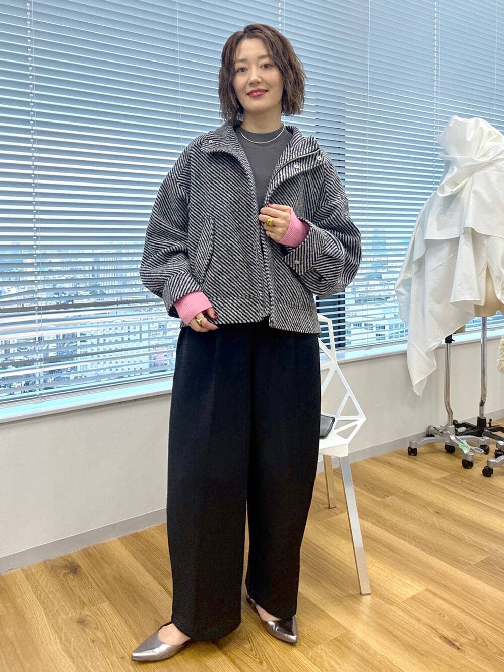 グレー系のニット/セーター、ブラック系のスウェットパンツ、グレー系のパンプスを着用したレディースの秋コーディネートの3枚目の写真