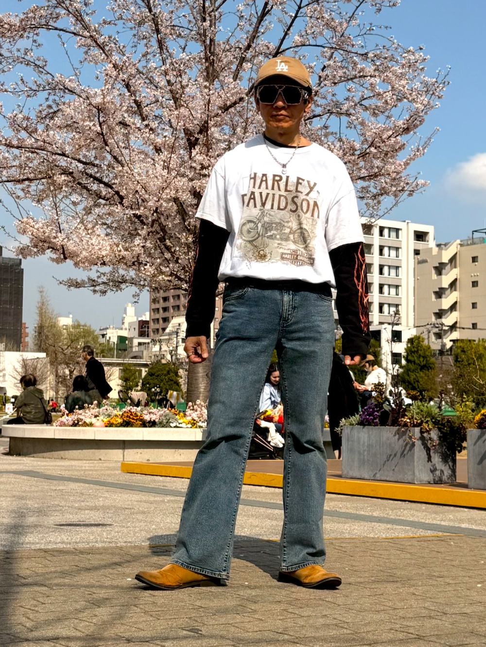 ホワイト系のTシャツ/カットソー、ブルー系のデニムパンツ、ブラウン系のブーツを着用したメンズの春コーディネートの2枚目の写真