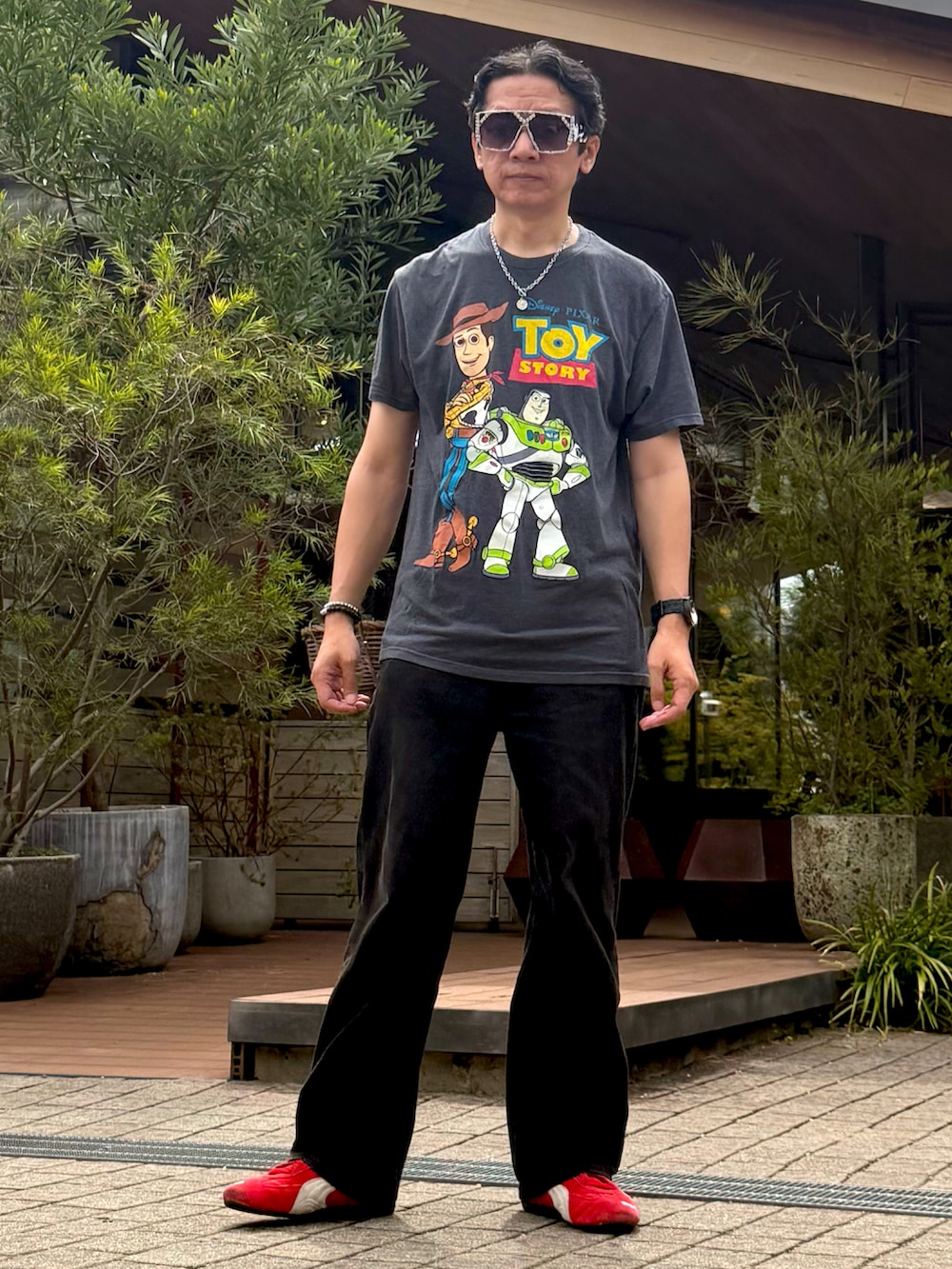 レッド系のスニーカー、グレー系のTシャツ/カットソー、ブラック系のデニムパンツを着用したメンズの夏コーディネートの2枚目の写真