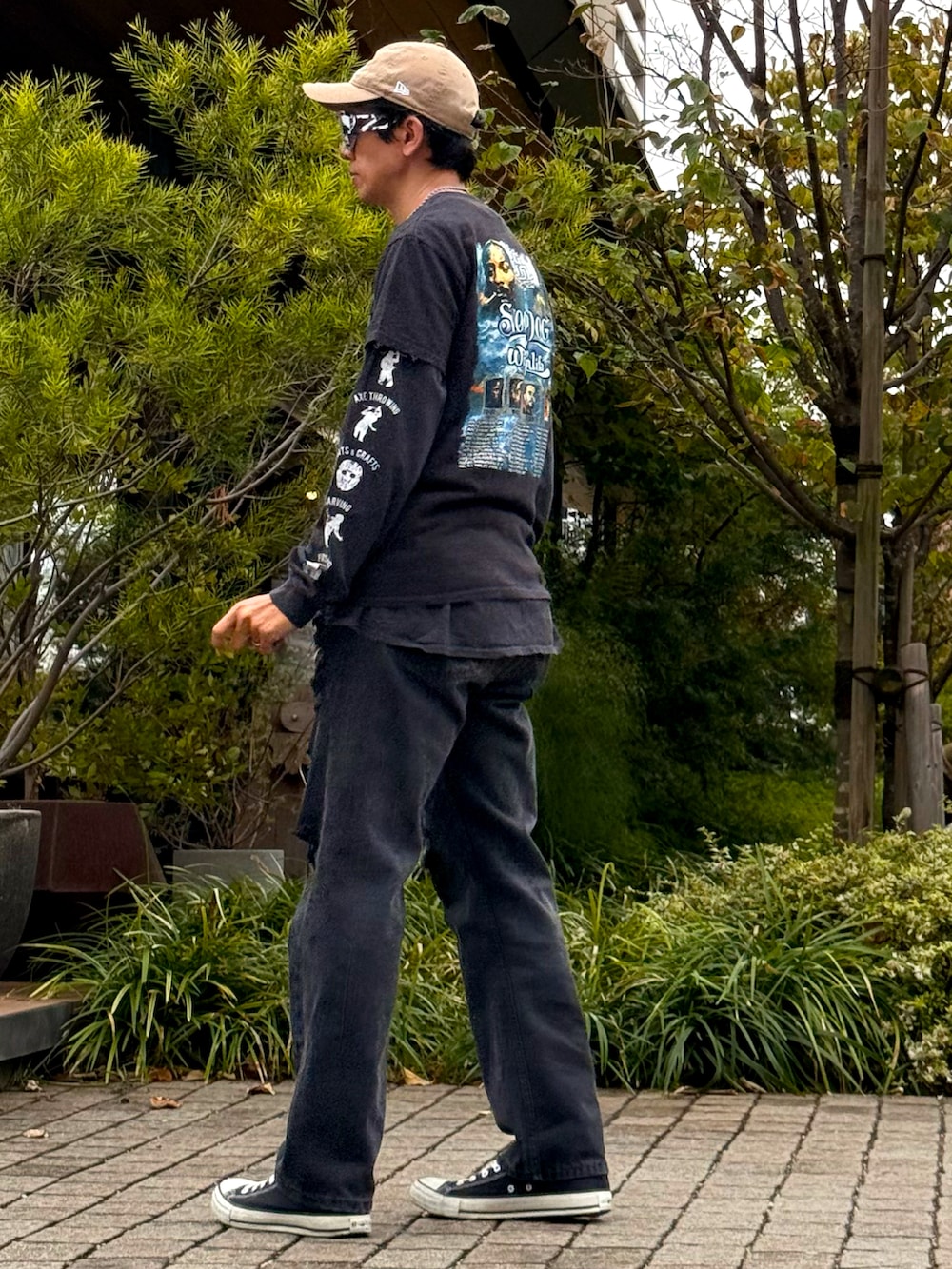 ブラック系のTシャツ/カットソー、ブラック系のデニムパンツ、ブラック系のスニーカーを着用したメンズの秋コーディネートの2枚目の写真