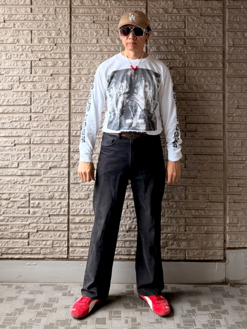 レッド系のスニーカー、ホワイト系のTシャツ/カットソー、ブラック系のデニムパンツを着用したメンズの春コーディネートの2枚目の写真
