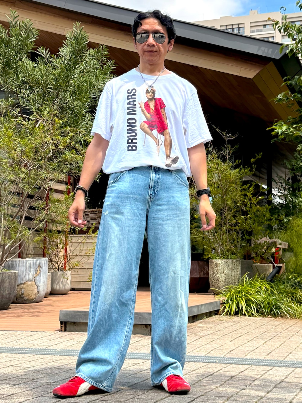 レッド系のスニーカー、ブラック系のシャツ/ブラウス、ホワイト系のTシャツ/カットソーを着用したメンズの夏コーディネートの3枚目の写真