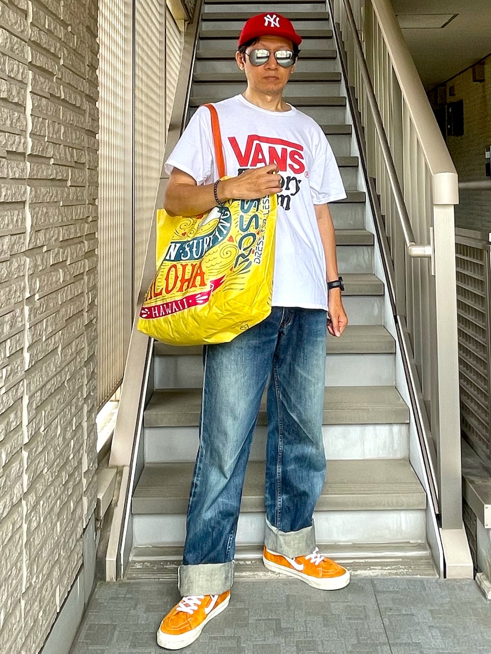 ホワイト系のTシャツ/カットソー、イエロー系のトートバッグ、ブルー系のデニムパンツを着用したメンズの夏コーディネートの3枚目の写真