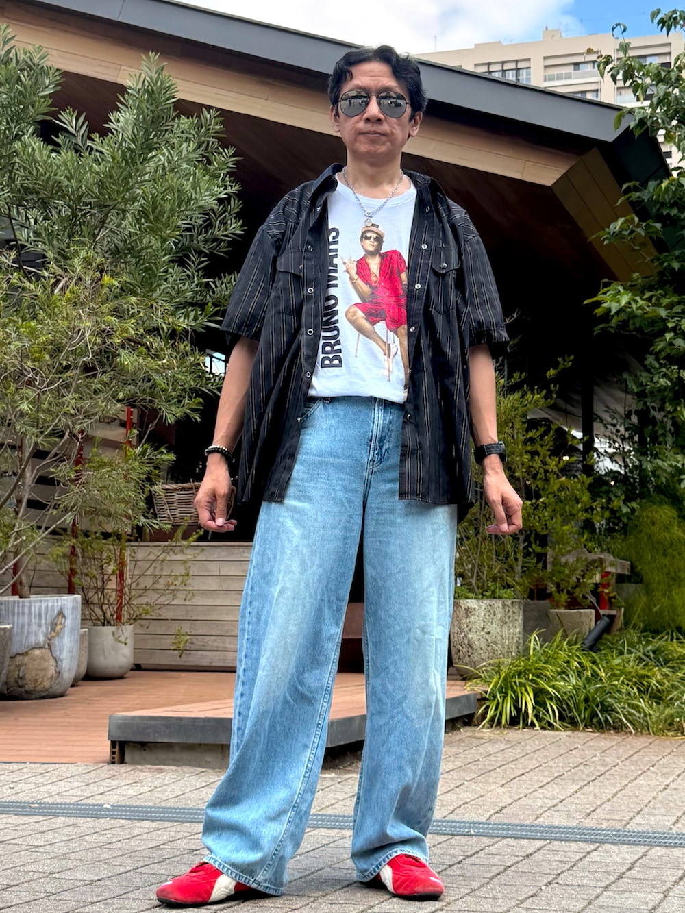 レッド系のスニーカー、ブラック系のシャツ/ブラウス、ホワイト系のTシャツ/カットソーを着用したメンズの夏コーディネートの2枚目の写真
