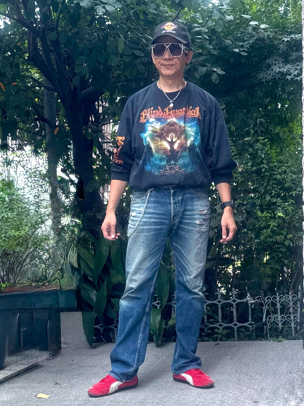 ブラック系のTシャツ/カットソー、ブルー系のデニムパンツ、レッド系のスニーカーを着用したメンズの秋コーディネートの3枚目の写真