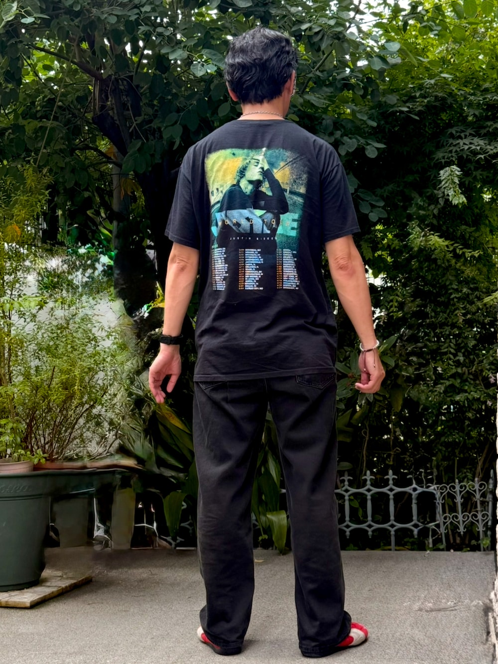 ブラック系のTシャツ/カットソー、ブラック系のデニムパンツ、レッド系のスニーカーを着用したメンズの夏コーディネートの2枚目の写真