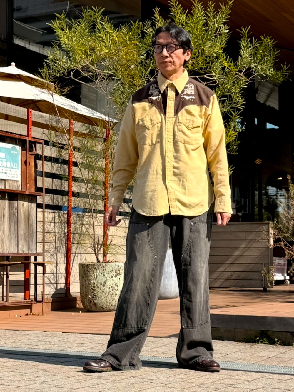 イエロー系のシャツ/ブラウス、ブラウン系のジャケット/アウター、グレー系のデニムパンツを着用したメンズの春コーディネートの5枚目の写真