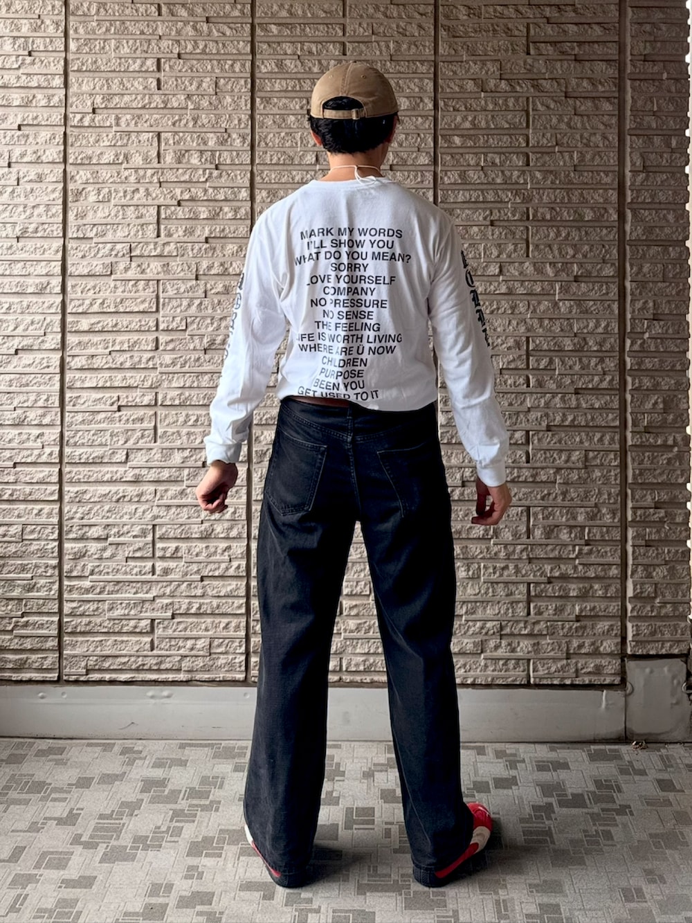 レッド系のスニーカー、ホワイト系のTシャツ/カットソー、ブラック系のデニムパンツを着用したメンズの春コーディネートの3枚目の写真