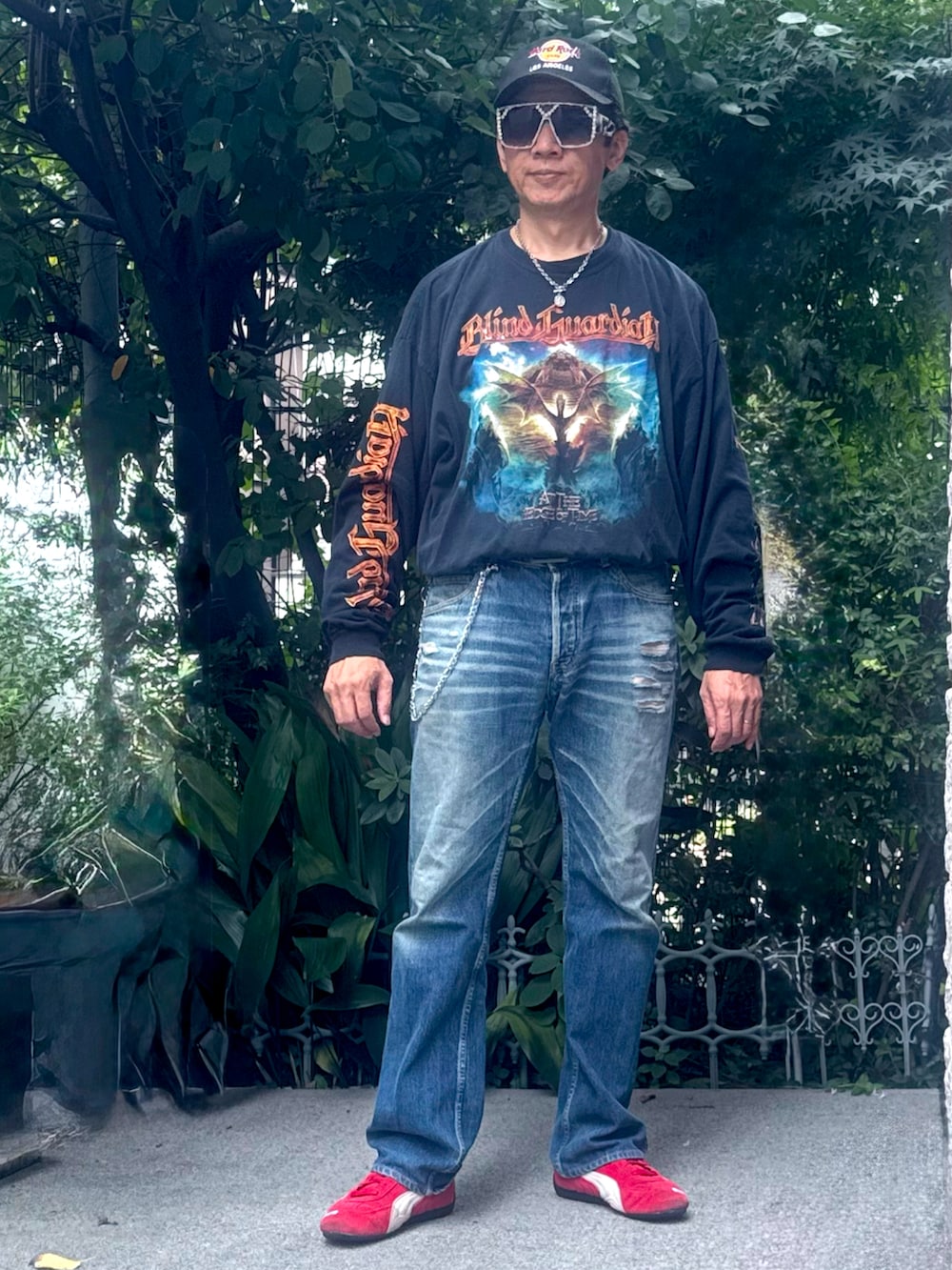 ブラック系のTシャツ/カットソー、ブルー系のデニムパンツ、レッド系のスニーカーを着用したメンズの秋コーディネートの2枚目の写真
