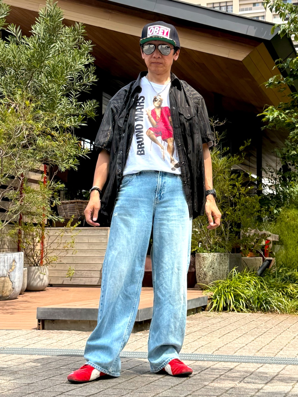 レッド系のスニーカー、ブラック系のシャツ/ブラウス、ホワイト系のTシャツ/カットソーを着用したメンズの夏コーディネートの5枚目の写真