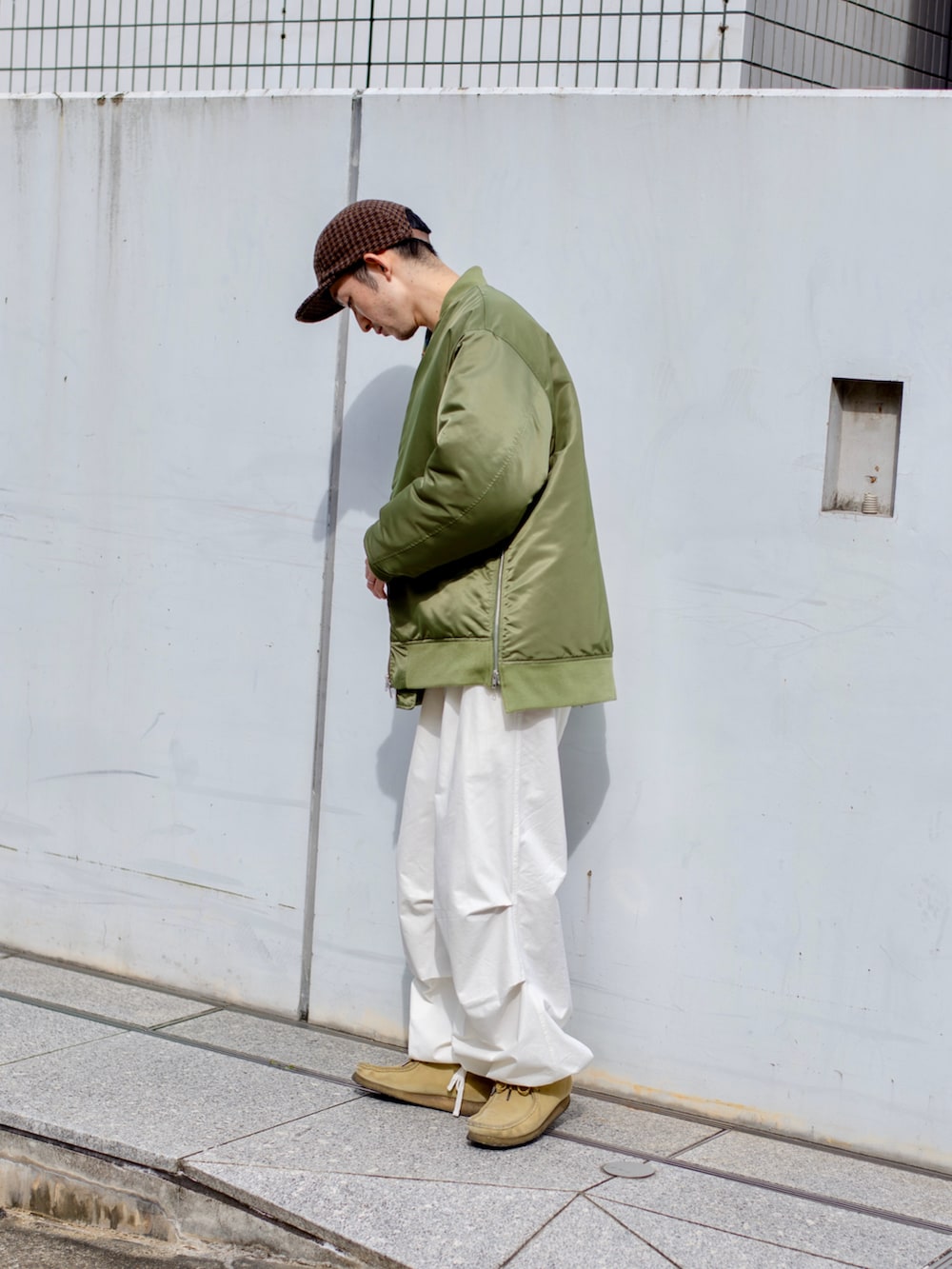 グリーン系のミリタリージャケット、グリーン系のニット/セーター、ホワイト系のその他パンツを着用したメンズの秋コーディネートの3枚目の写真