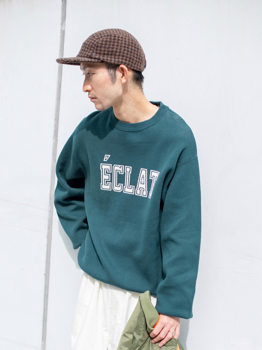 グリーン系のミリタリージャケット、グリーン系のニット/セーター、ホワイト系のその他パンツを着用したメンズの秋コーディネートの4枚目の写真