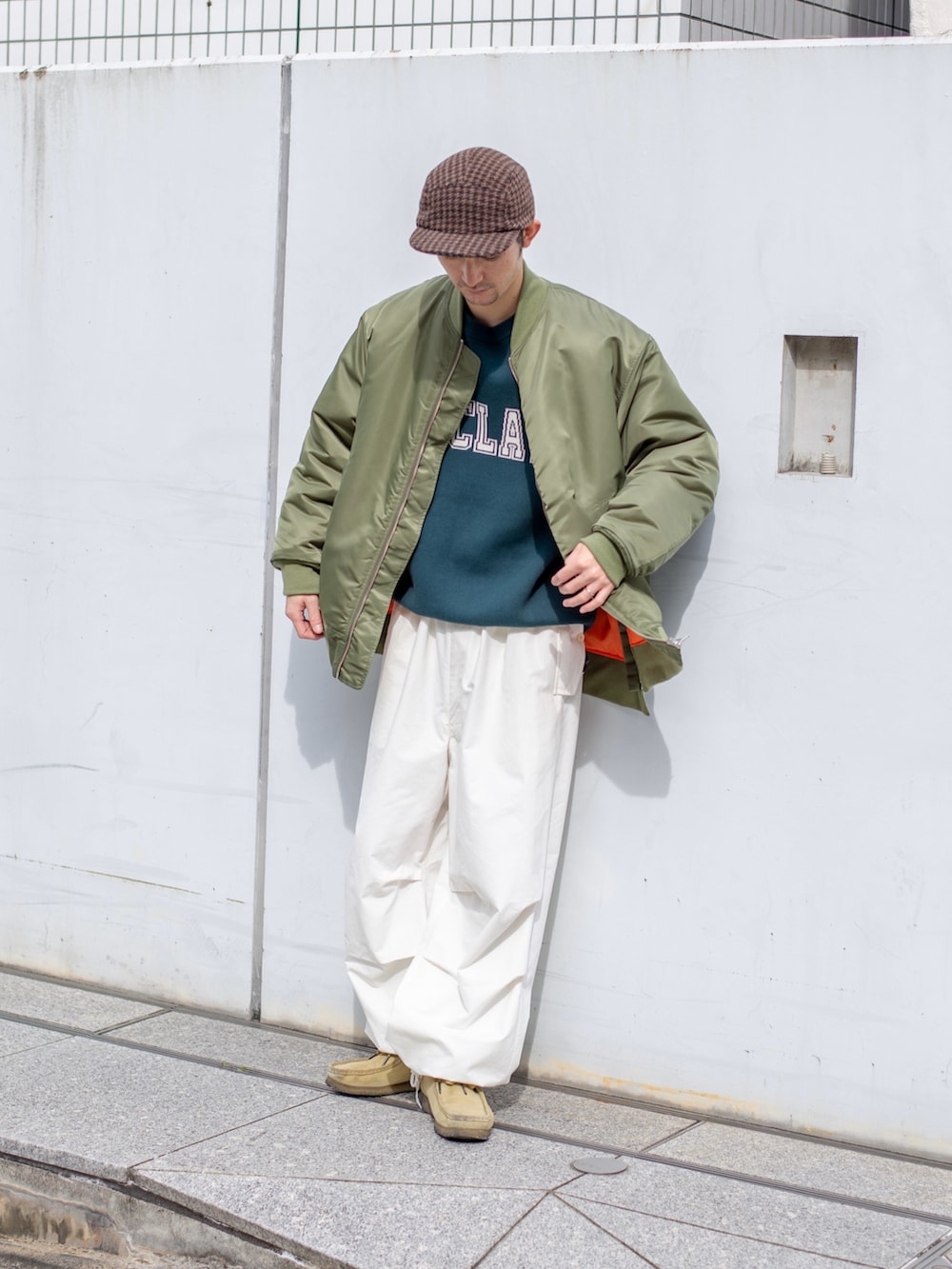 グリーン系のミリタリージャケット、グリーン系のニット/セーター、ホワイト系のその他パンツを着用したメンズの秋コーディネートの2枚目の写真