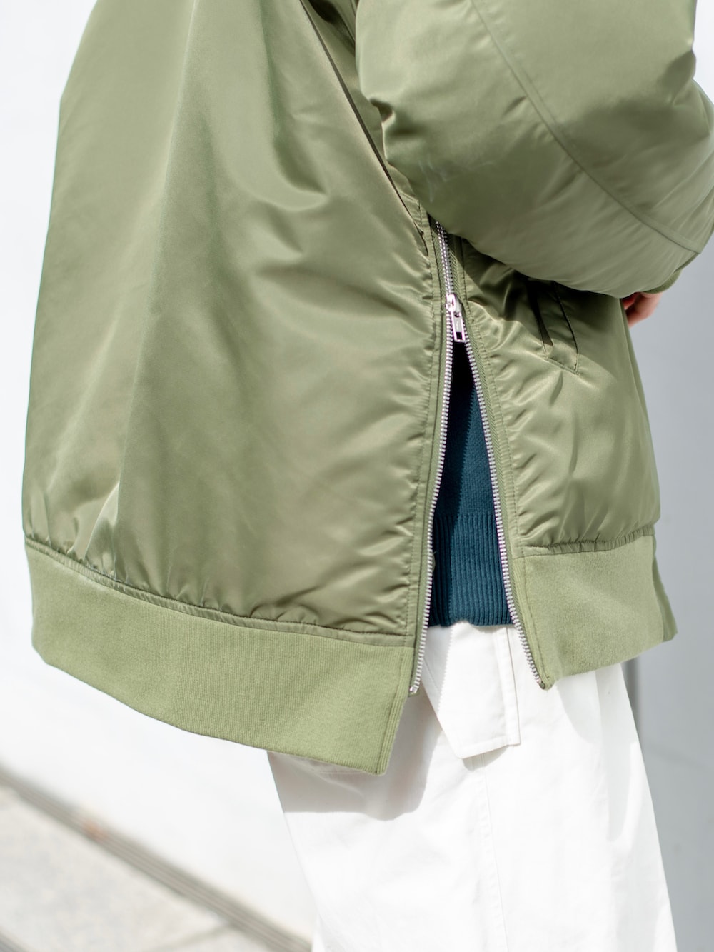 グリーン系のミリタリージャケット、グリーン系のニット/セーター、ホワイト系のその他パンツを着用したメンズの秋コーディネートの5枚目の写真