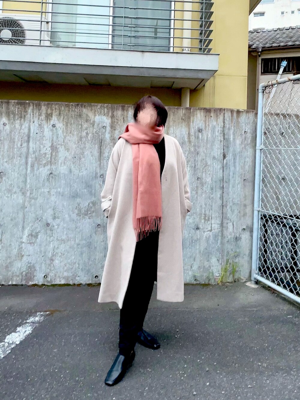 ベージュ系のノーカラーコート、ブラック系のニット/セーター、ブラック系のデニムパンツを着用したレディースの秋コーディネートの2枚目の写真