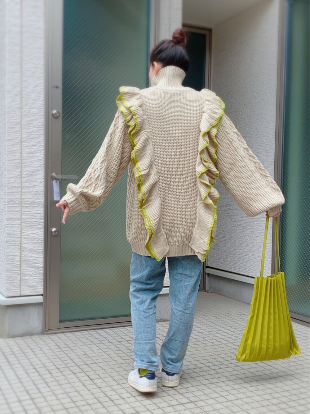 ホワイト系のニット/セーター、グリーン系のトートバッグ、ホワイト系のスニーカーを着用したレディースの冬コーディネートの2枚目の写真