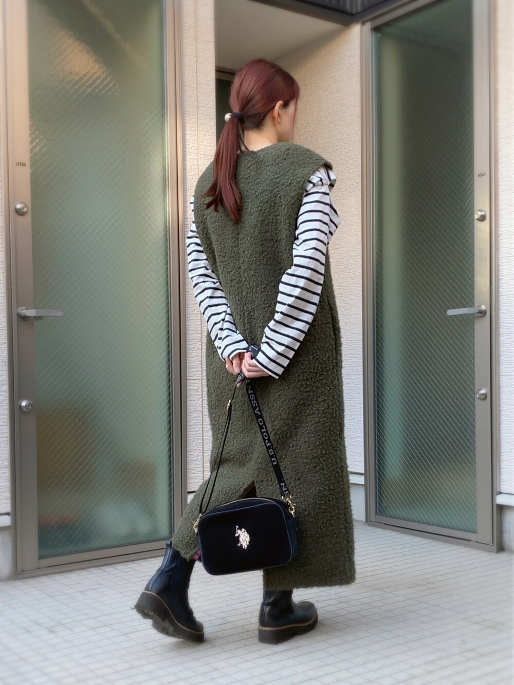 ホワイト系のTシャツ/カットソー、ブラック系のショルダーバッグ、ブラック系のブーツを着用したレディースの秋コーディネートの2枚目の写真