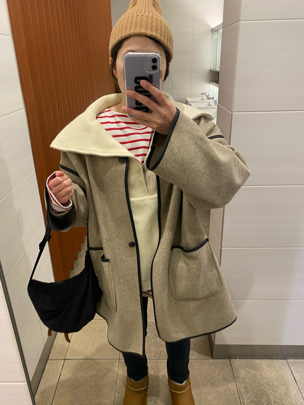 ホワイト系のニット/セーター、ベージュ系のその他アウター、ブラック系のボディバッグ/ウエストポーチを着用したレディースの秋コーディネートの2枚目の写真