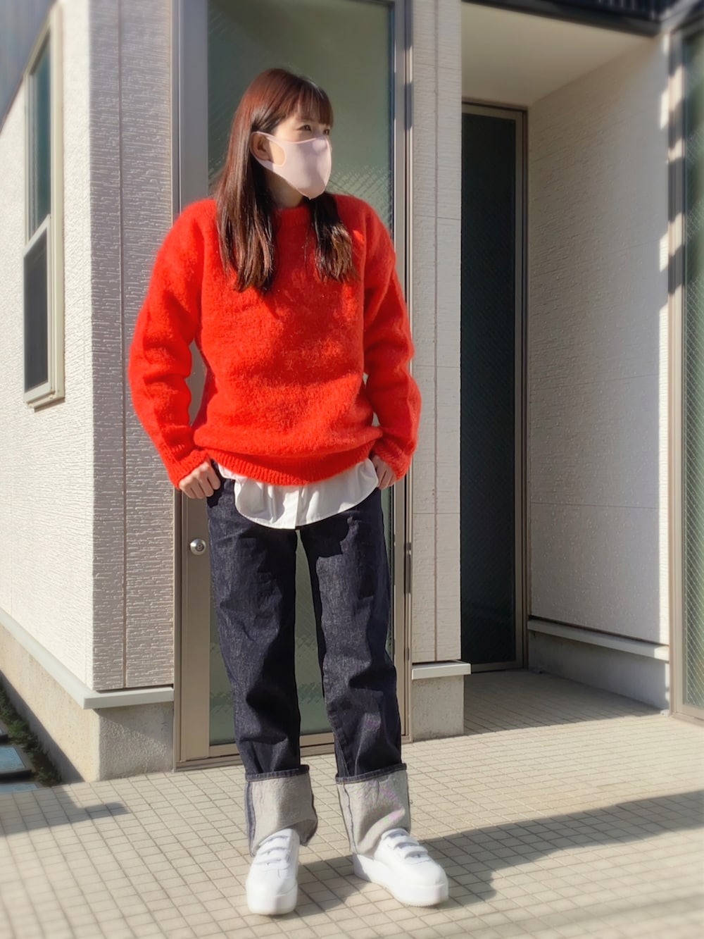 ピンク系のニット/セーター、ブルー系のデニムパンツ、ホワイト系のスニーカーを着用したレディースの冬コーディネートの2枚目の写真