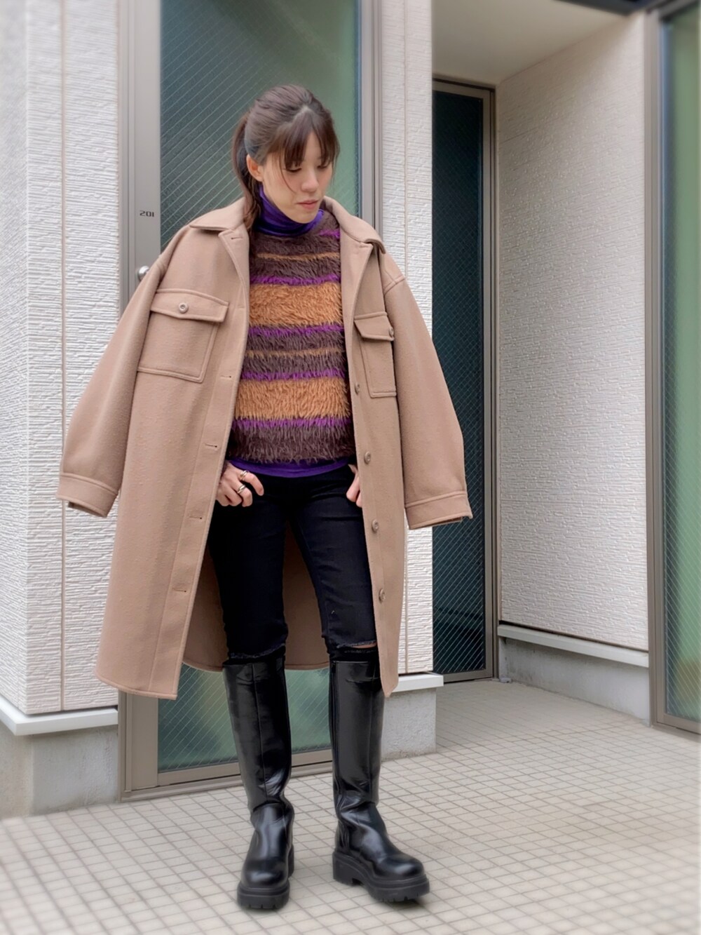 ブラック系のデニムパンツ、ブラック系のブーツ、ブラウン系のニット/セーターを着用したレディースの秋コーディネートの2枚目の写真