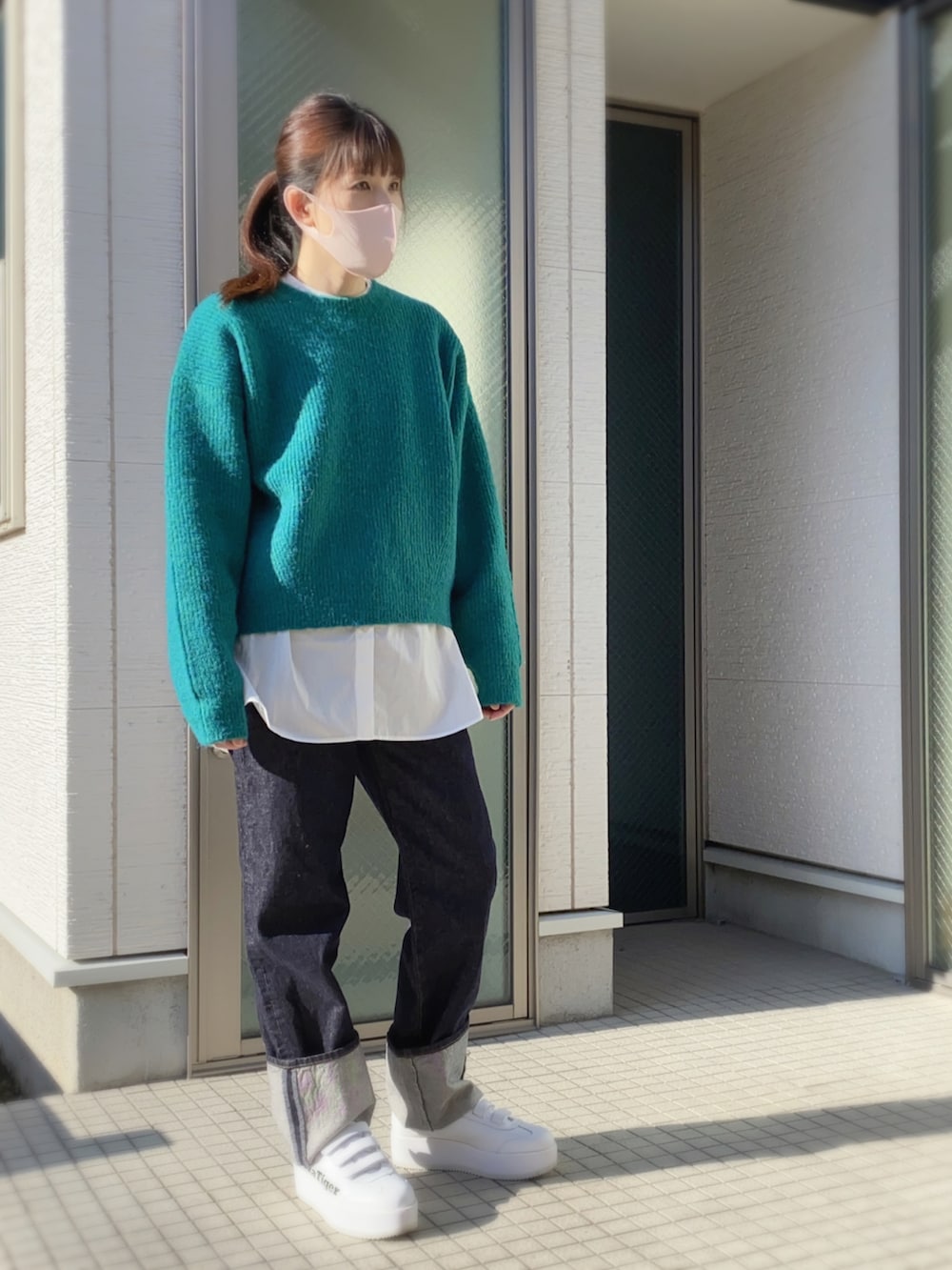 ピンク系のニット/セーター、ブルー系のデニムパンツ、ホワイト系のスニーカーを着用したレディースの冬コーディネートの3枚目の写真