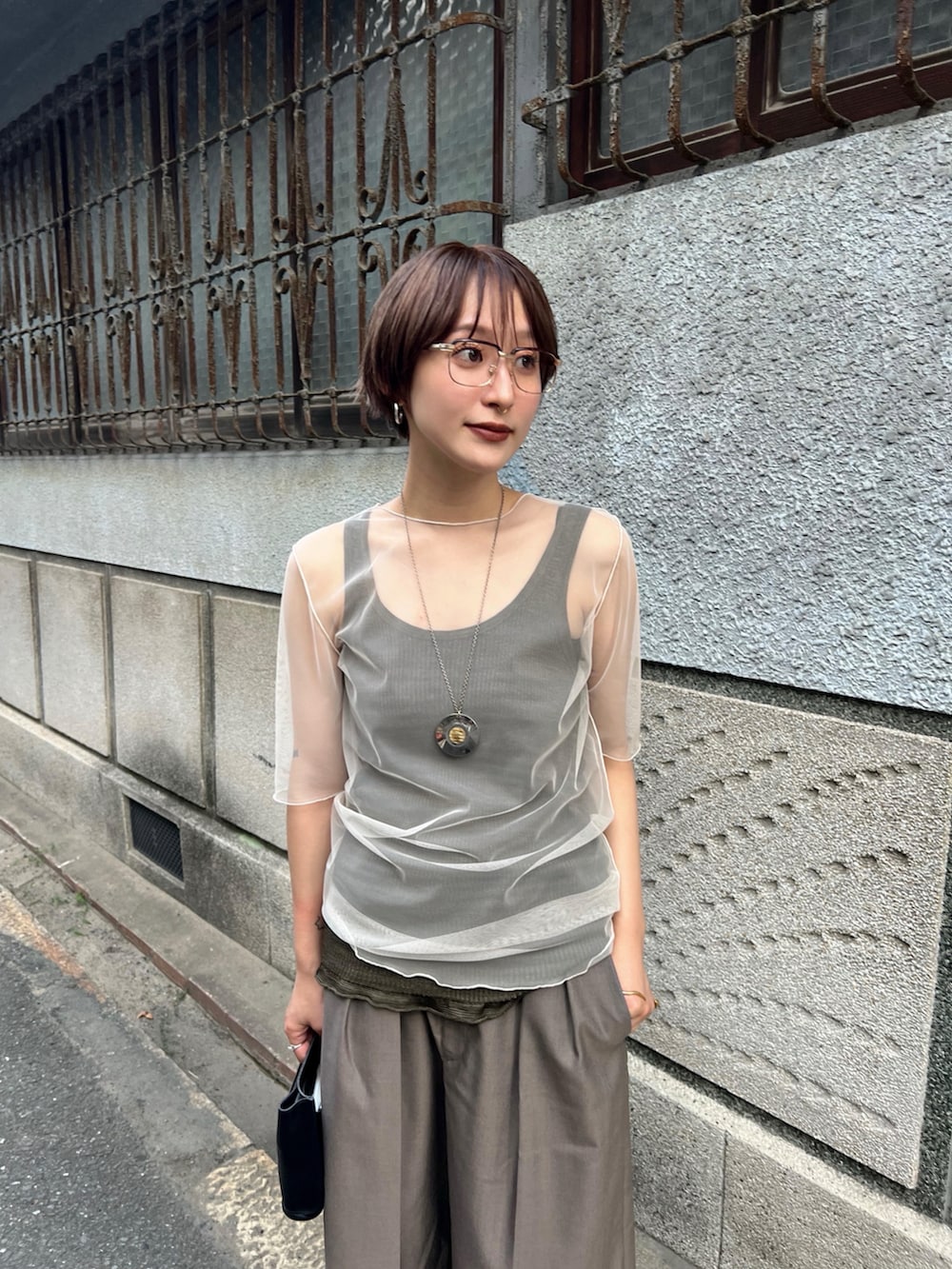 ブラウン系のその他パンツ、ブラック系のハンドバッグ、ベージュ系のTシャツ/カットソーを着用したレディースの夏コーディネートの2枚目の写真