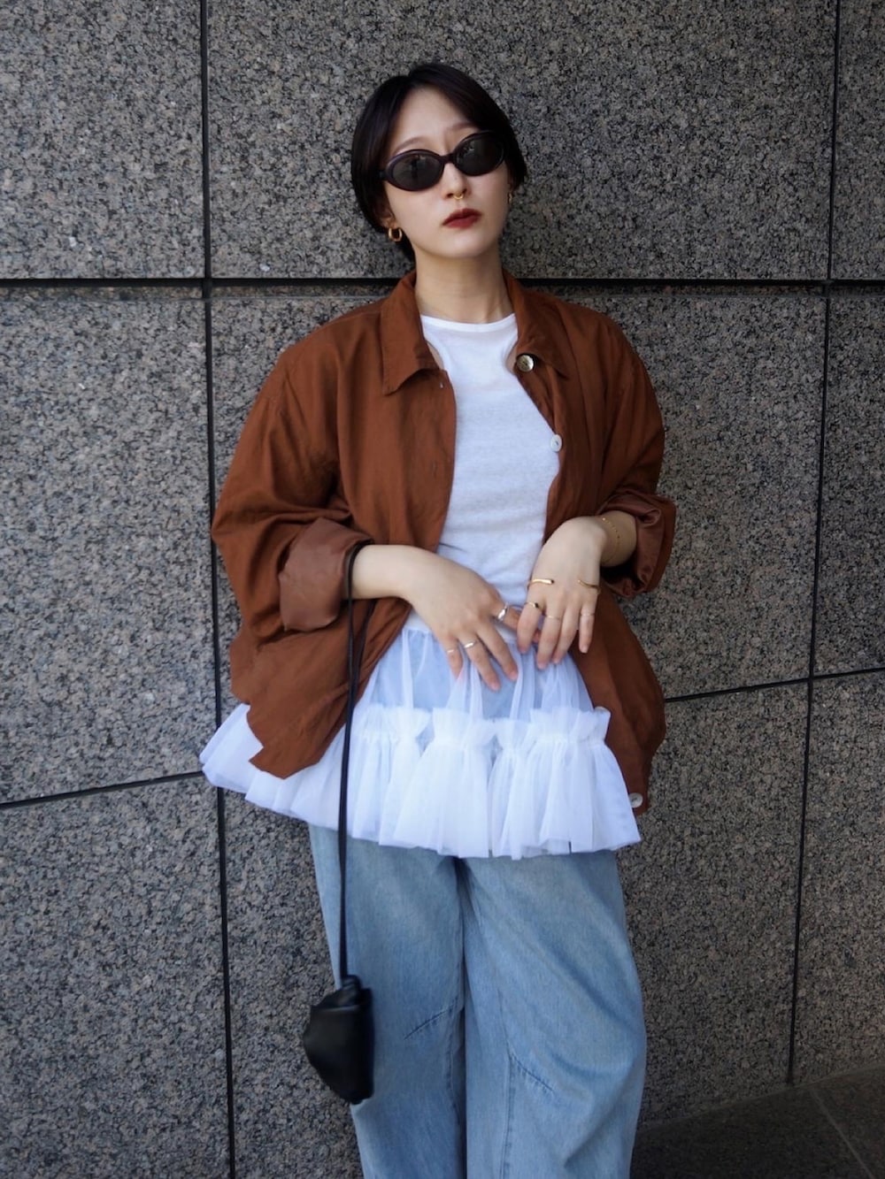 ホワイト系のスカート、ブラック系のショルダーバッグ、ブルー系のシューズを着用したレディースの夏コーディネートの2枚目の写真