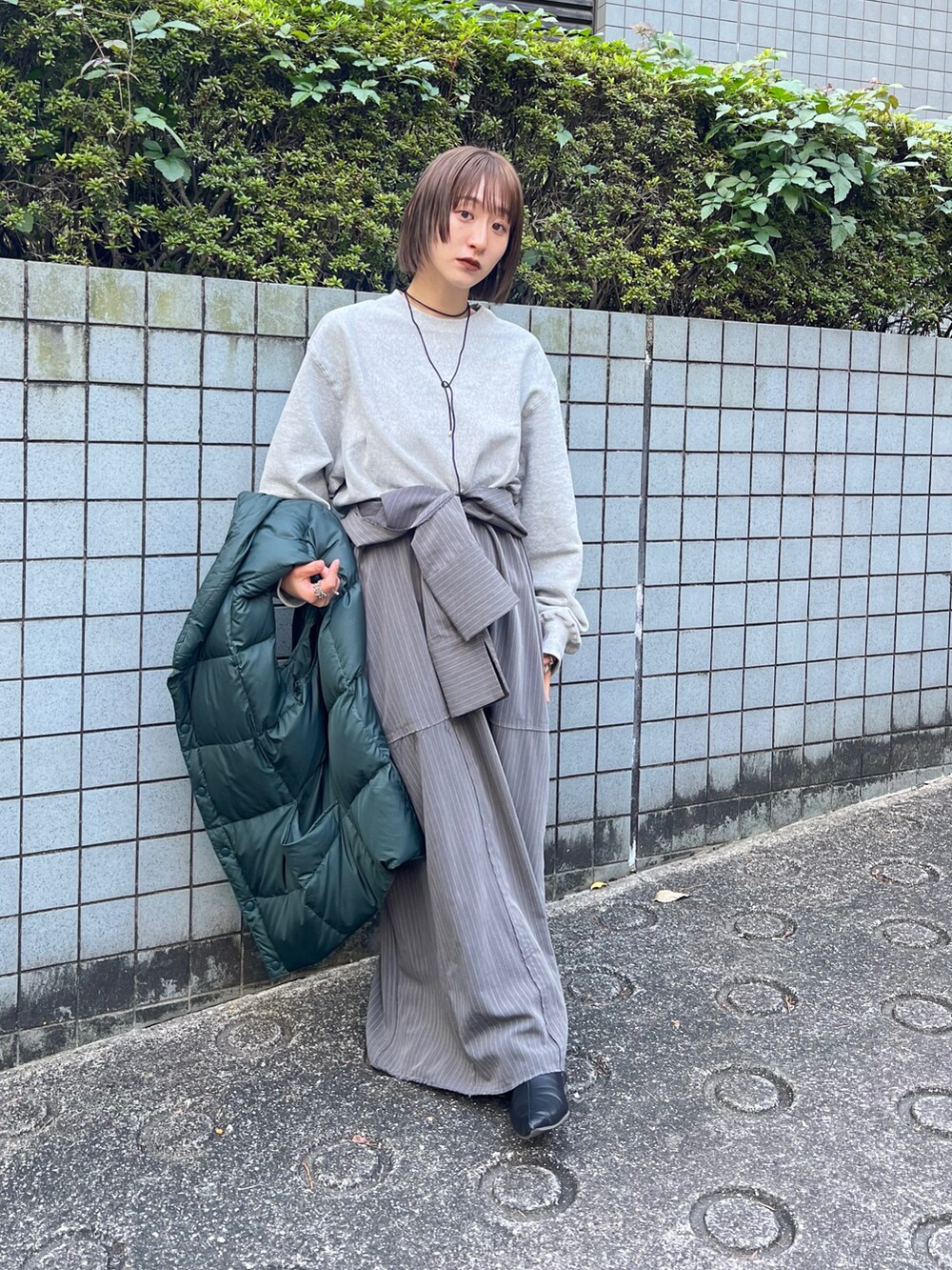 グレー系のワンピース、ブラック系のブーツを着用したレディースの秋コーディネートの2枚目の写真