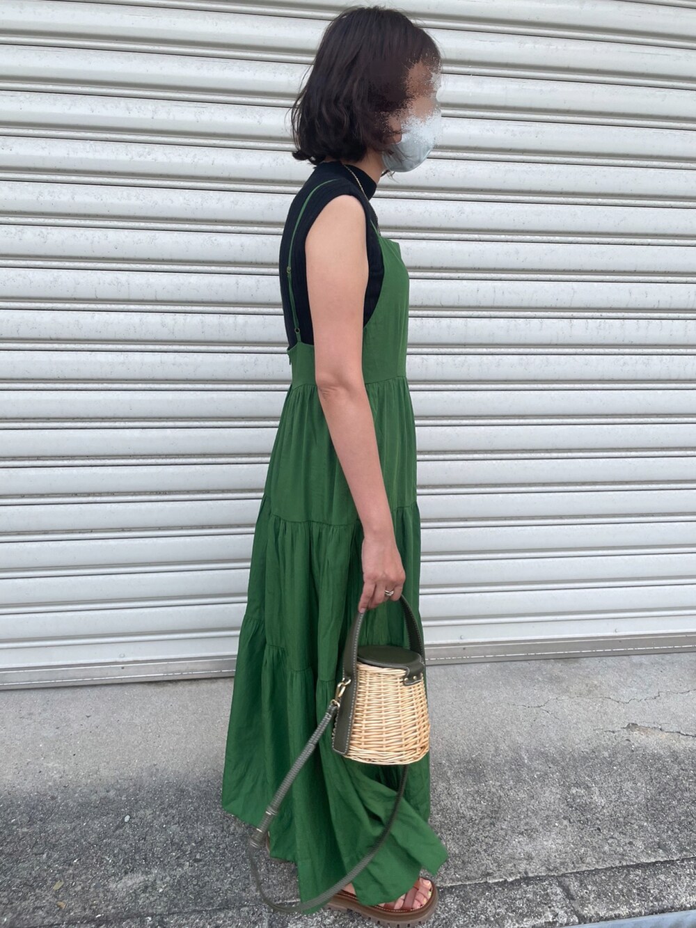 ブラック系のニット/セーター、グリーン系のワンピース、ブラウン系のサンダルを着用したレディースの夏コーディネートの2枚目の写真