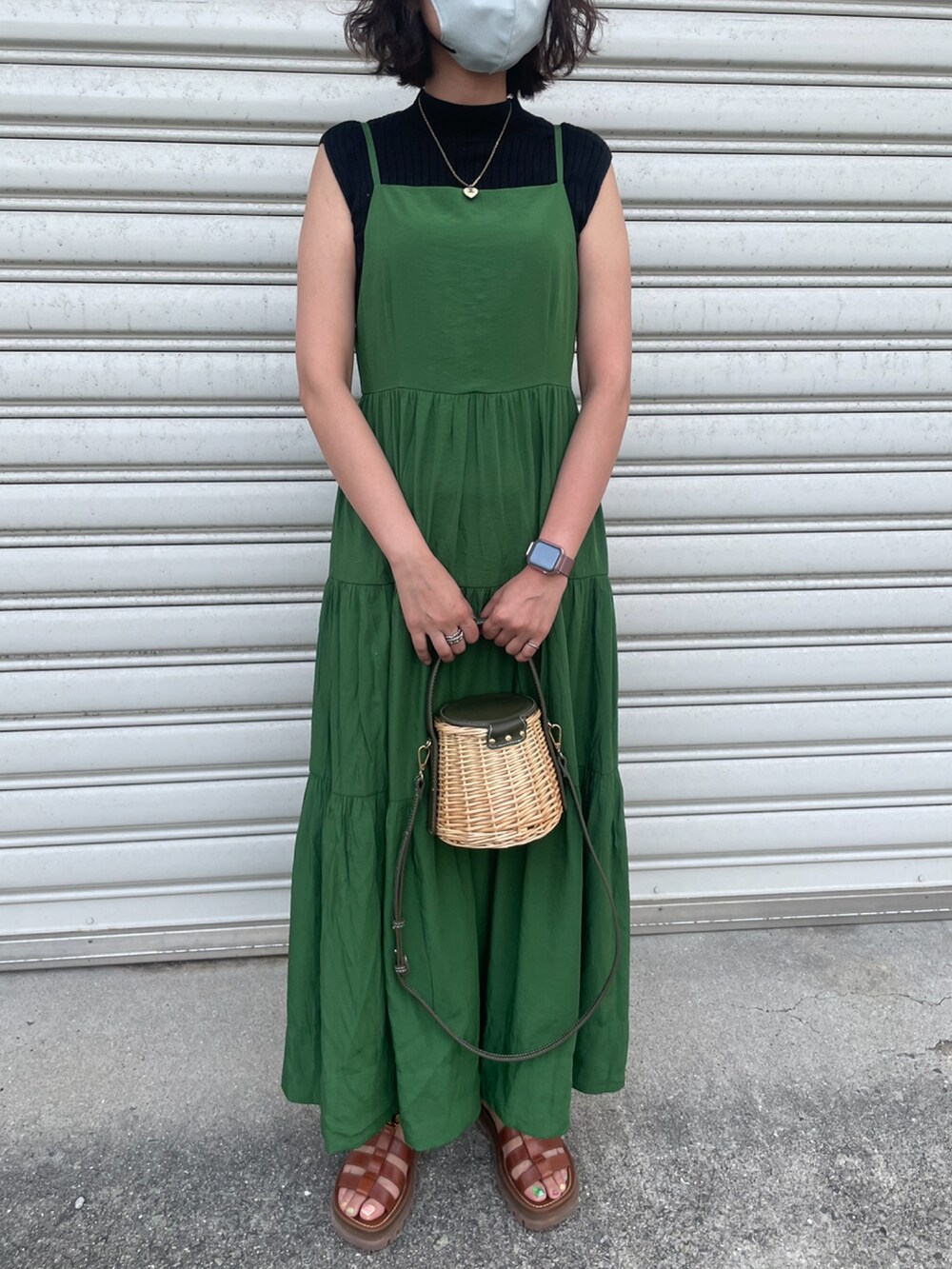 ブラック系のニット/セーター、グリーン系のワンピース、ブラウン系のサンダルを着用したレディースの夏コーディネートの3枚目の写真