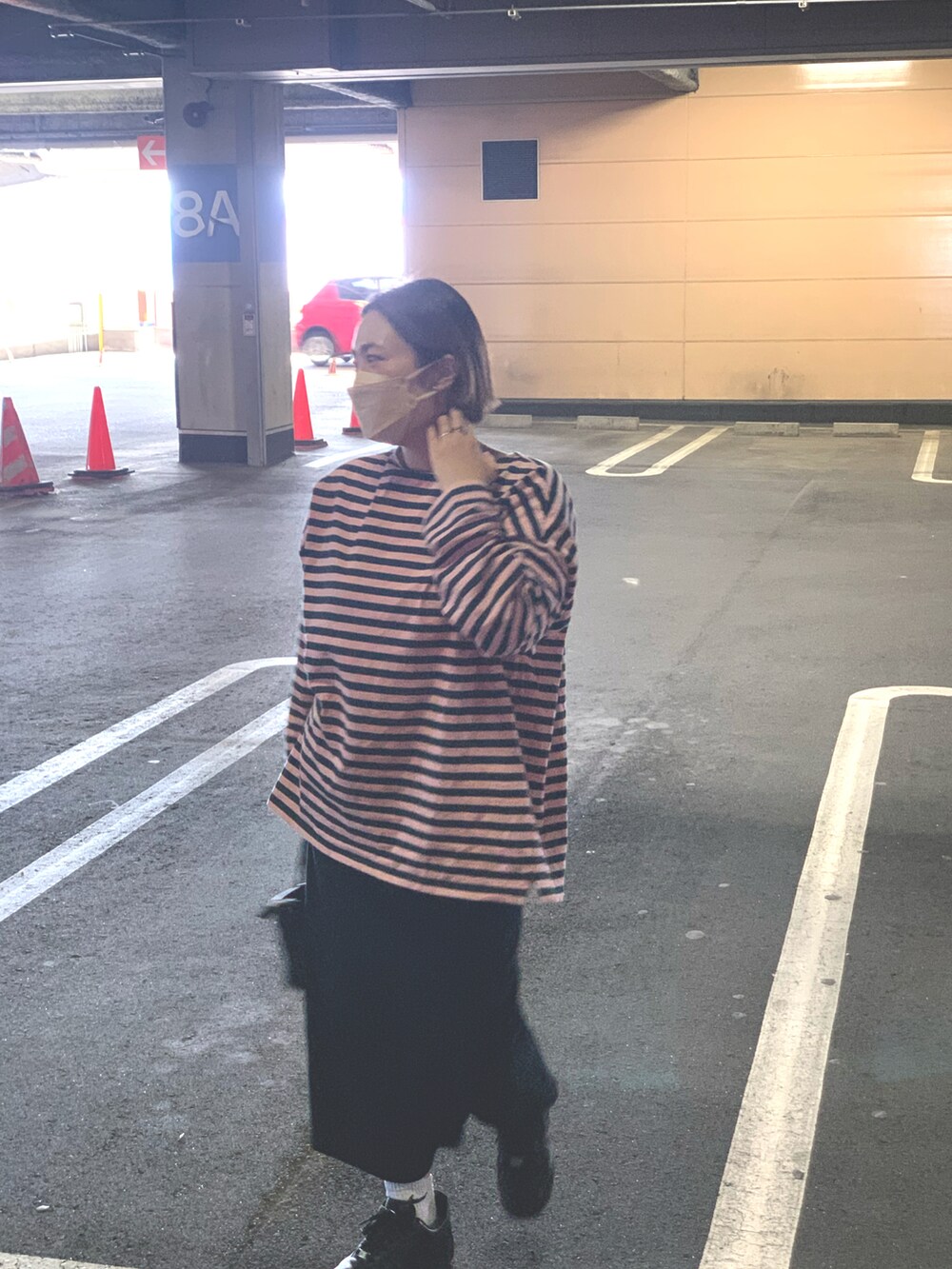 ブラック系のスニーカー、ピンク系のTシャツ/カットソー、ブラック系のスカートを着用したレディースの春コーディネートの2枚目の写真