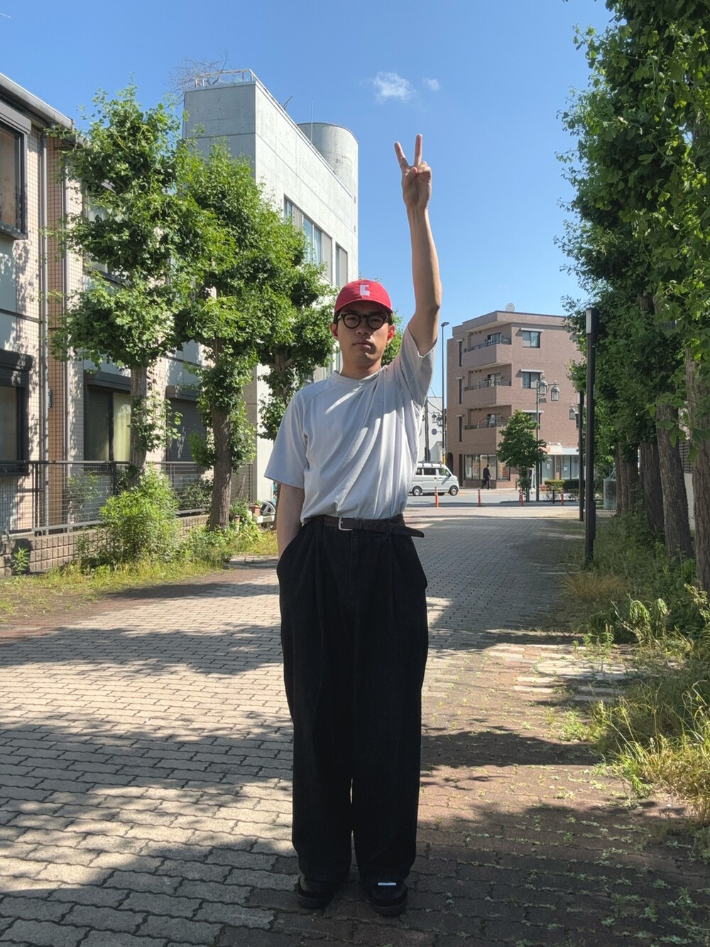 グレー系のTシャツ/カットソー、ブラック系のデニムパンツ、ブラック系のスニーカーを着用したメンズの夏コーディネートの3枚目の写真